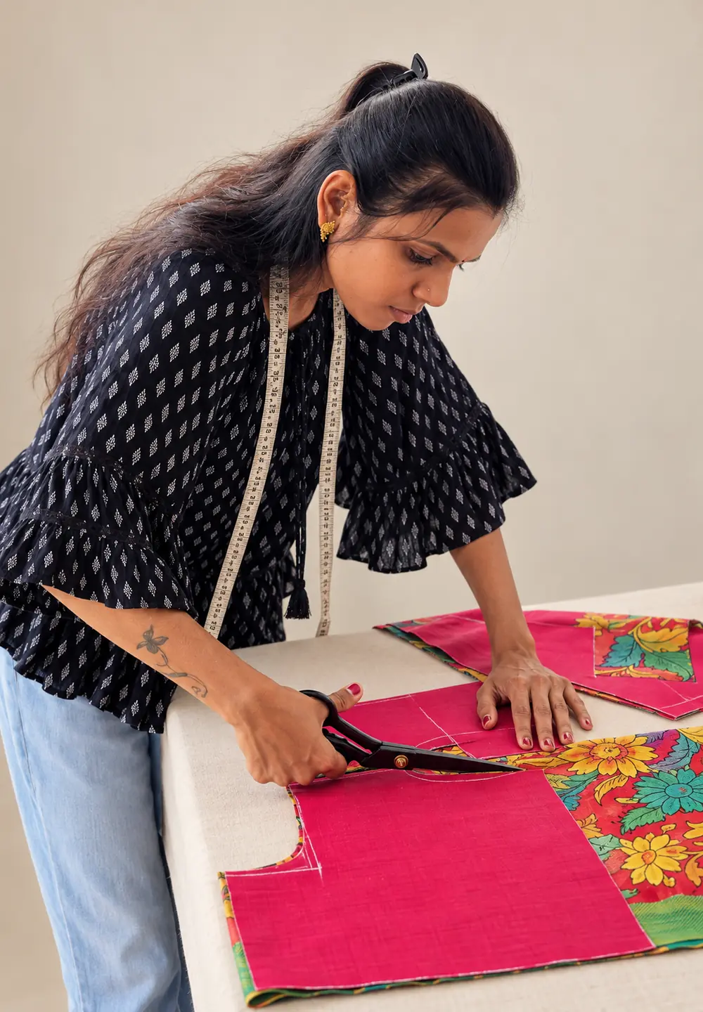 SACH Couture’s principal tailor carefully cutting garment fabric with tailoring shears